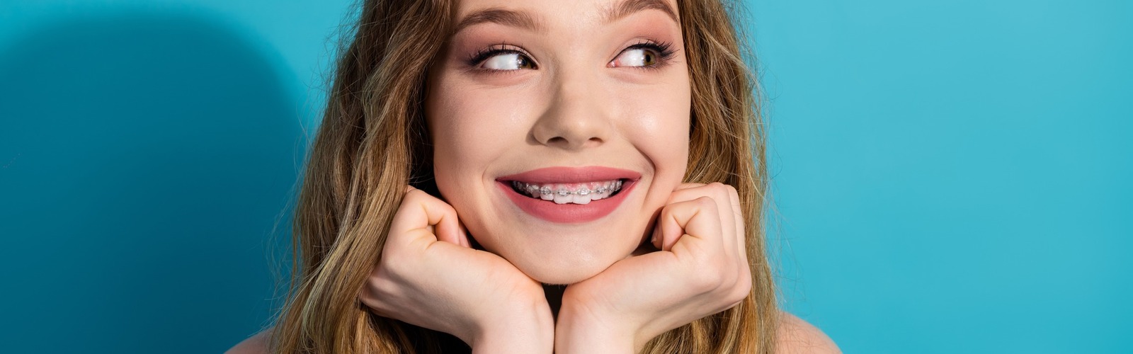 Junge Frau lächelt und zeigt ihre Zahnspange