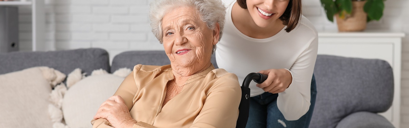 Seniorin im Rollstuhl und junge Frau haben gute Laune 