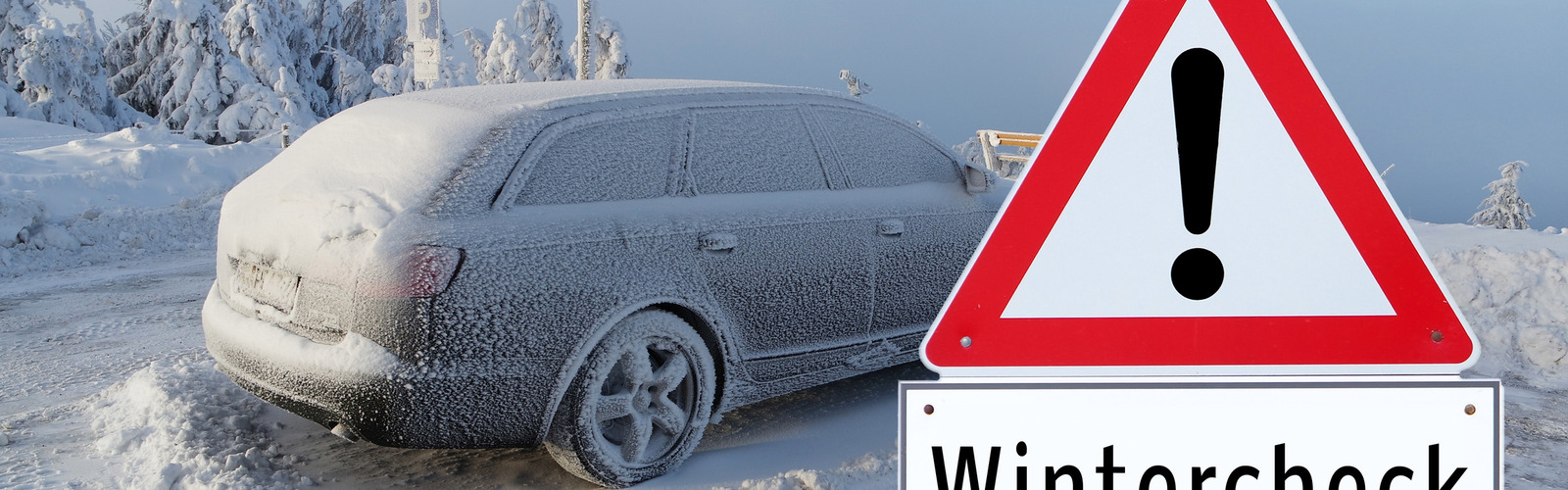 Eingeschneites Auto steht hinter einem Hinweisschild "Wintercheck"
